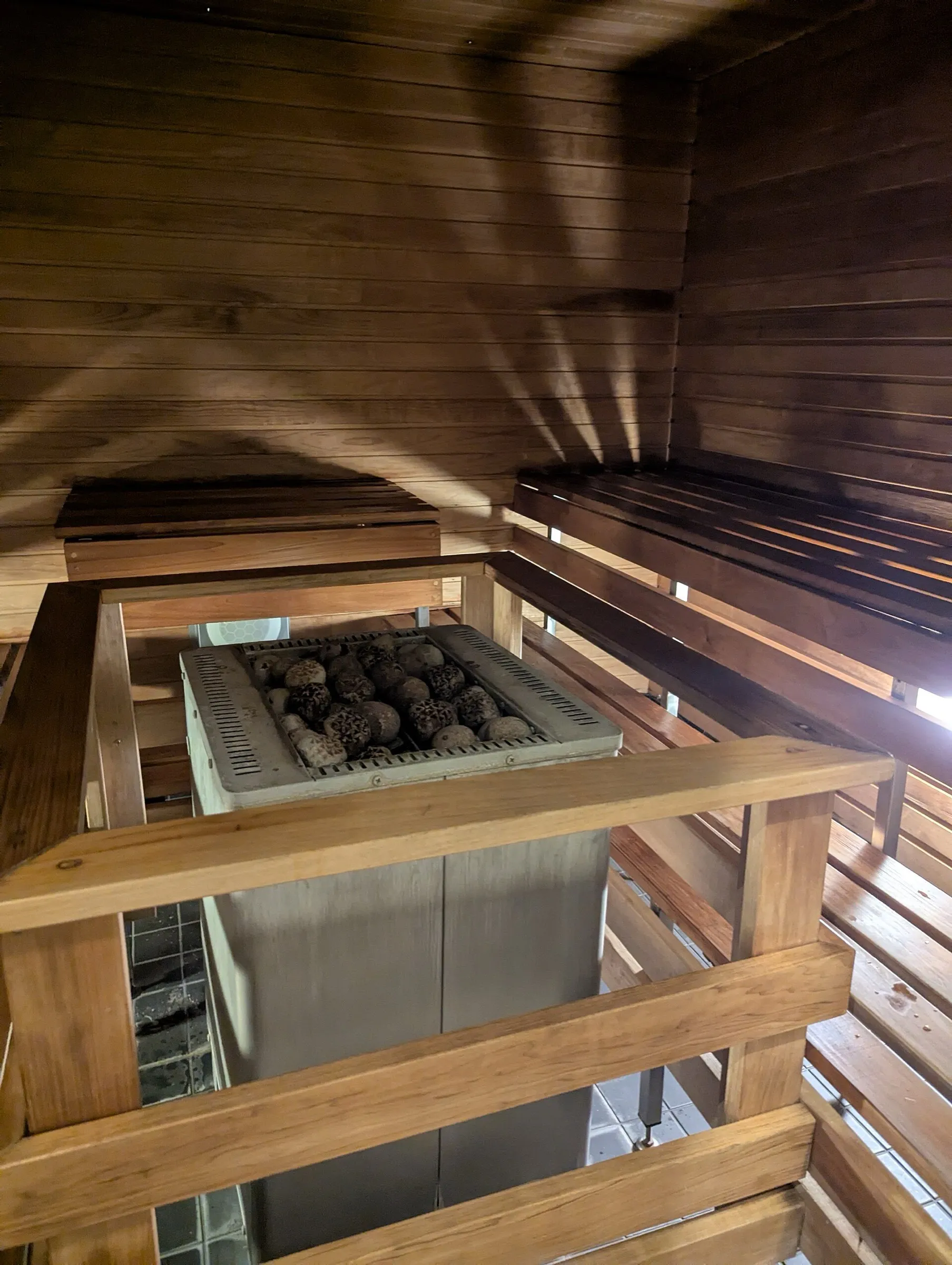 Calefactor de sauna rodeado de madera y bancos a medida