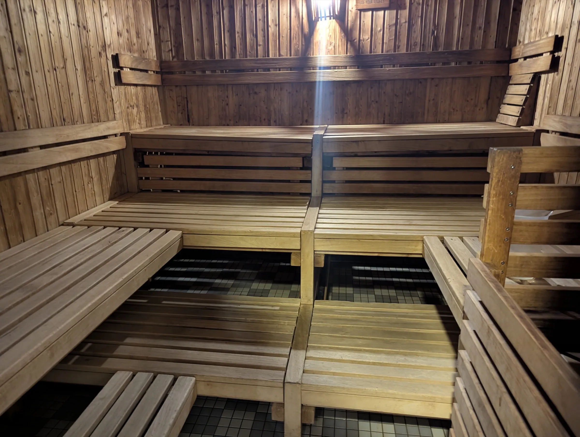 Sauna de uso comercial con bancos corridos de madera